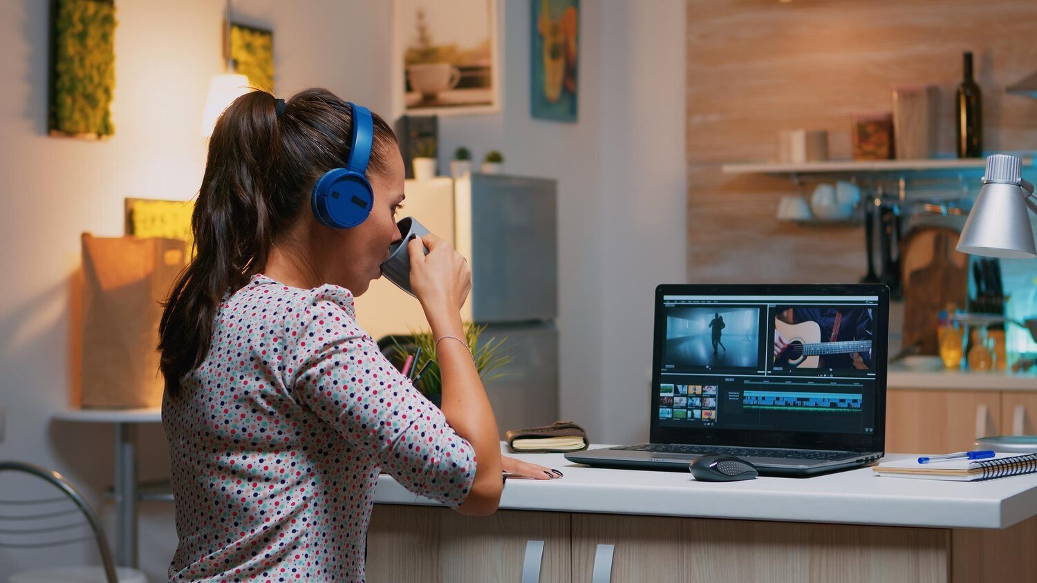 Woman video editor wearing headset working on footage and audio editing on laptop at night, representing video animation services in Lahore, 2D and 3D animation, video production, and post production editing